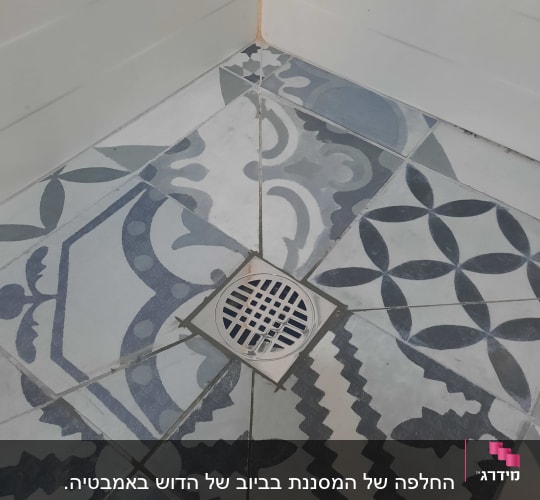 רצפת מקלחת עם ריצוף מעוצב וניקוז מתכת עגול